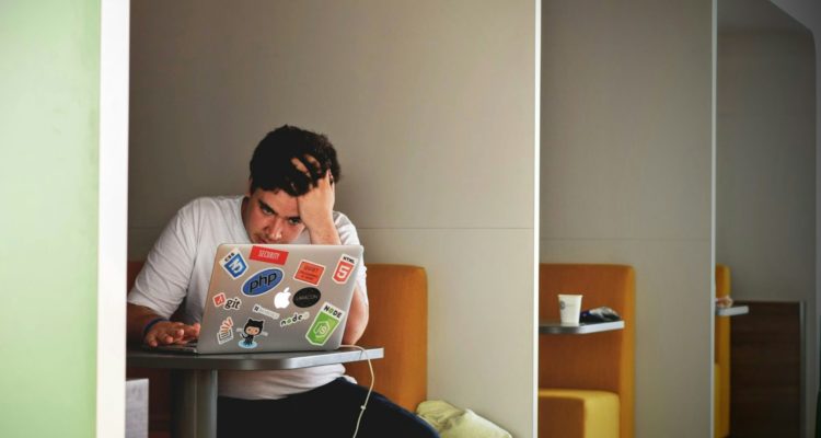 man wearing white top using MacBook